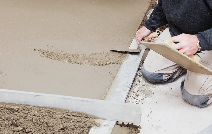 Ouvrier réalisant une chape de béton